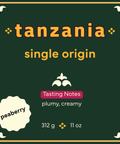 square coffee bag label with 'tanzania single origin' text and peaberry description on a green background with yellow and white text